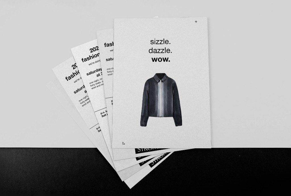 Printed Stromfeld fashion show postcards fanned on a table, showing front and back